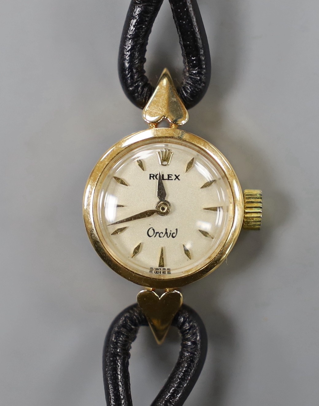 A lady's mid 20th century 750 yellow metal Rolex Orchid manual wind wrist watch, with engraved inscription, on associated leather strap.